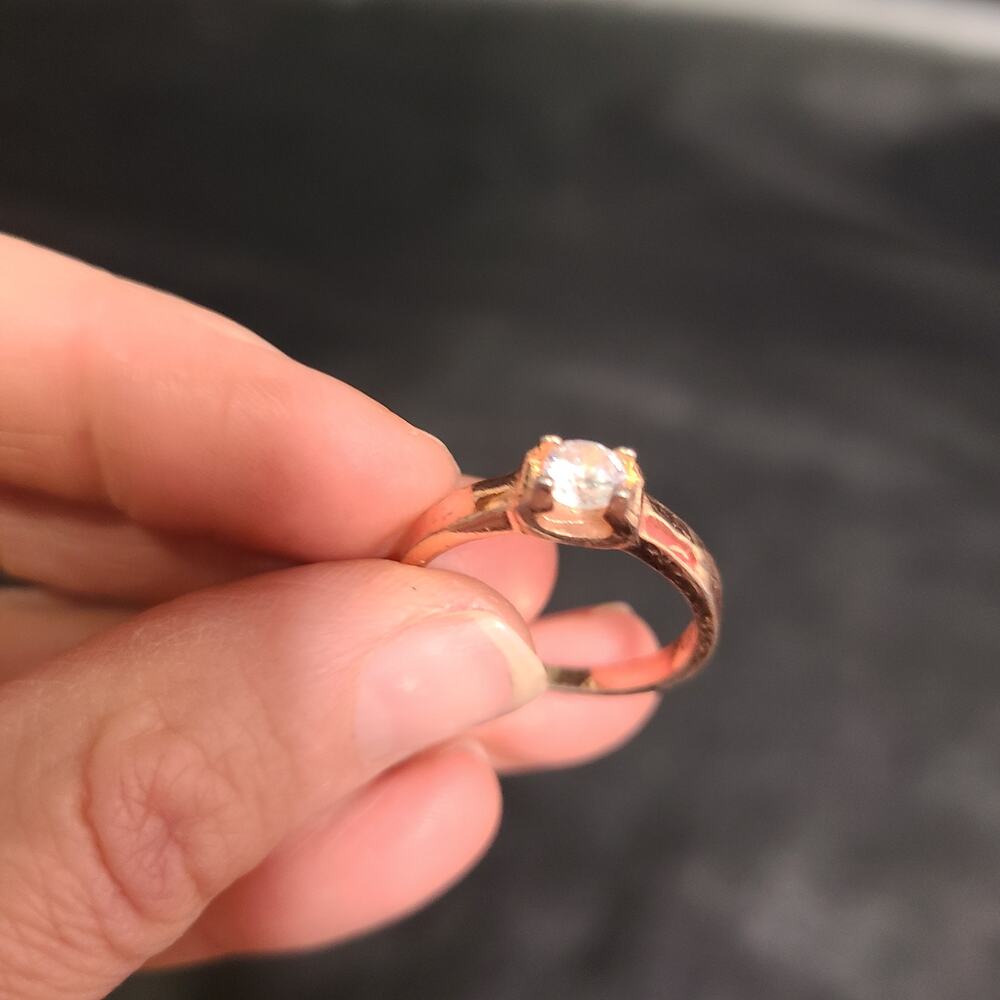 Rose gold solitaire ring with a round clear gemstone set in four prong size 9